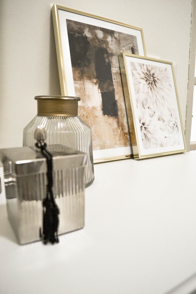 Styiling ingresso con stampe in cornici dorate e accessori 